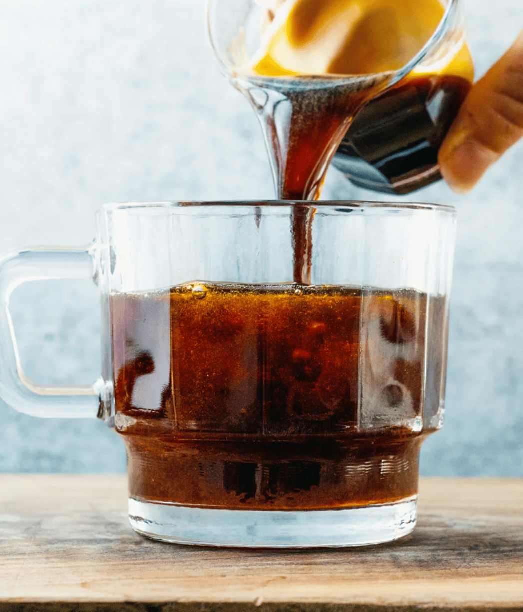 a cup of coffee with a shot of espresso being poured in